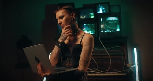 Edgy Woman Works on Laptop in Dark Room