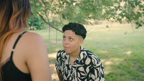 A lesbian Latin proposing in a park to her partner. Celebrate love and diversity. Support for the L