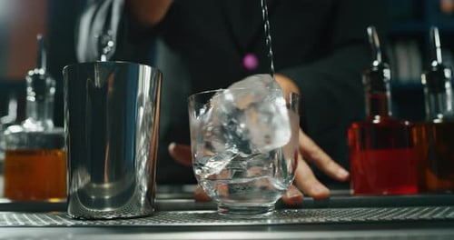 Close up of a professional bartender is preparing an alcoholic cocktail with professional crystal
