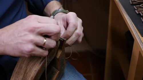 Couture artisanale à la main d'un bracelet de montre en cuir de luxe selon la technique du point sellier