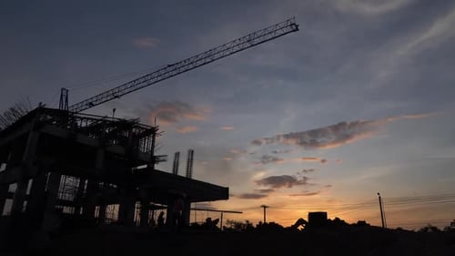Bau bei Sonnenuntergang Massiver Kran und Silhouette der Gebäudestruktur im Zeitraffer