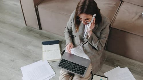 Woman Works and Talks on Phone at Home