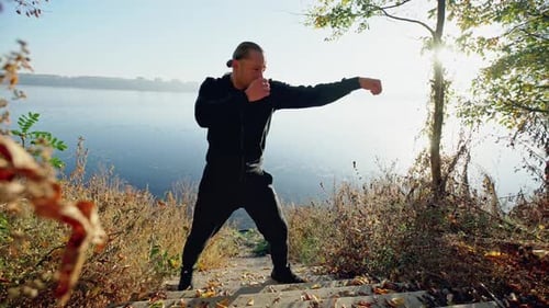 Man Practicing Martial Arts Training Outdoors by Lake