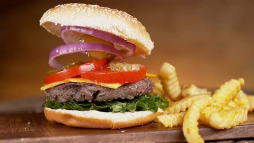 Hamburger falls in slow motion onto a wooden surface phantom flex 4k