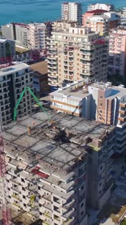 Vídeo vertical de ingenieros supervisando la construcción mientras una grúa levanta vigas y los trabajadores construyen