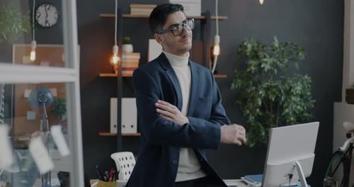 Slow Motion Portrait of Confident Middle Eastern Executive in Suit Standing in Office Crossing Arms