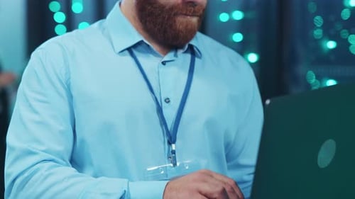Man Typing on Laptop in Data Center