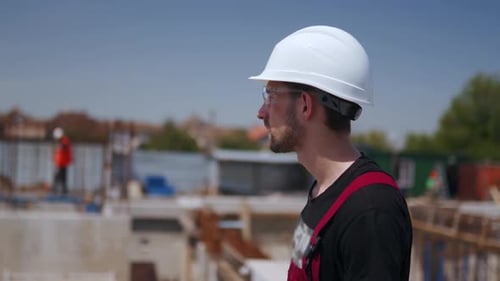 Construction Worker Overseeing Building Site on Sunny Day
