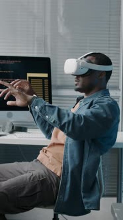 Vertical of Black Man Wearing VR Headset while Working in Office