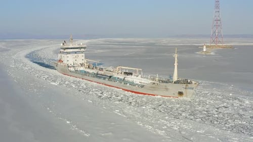 Oil Tanker Among the Ice Passes the Frozen Strait in Winter