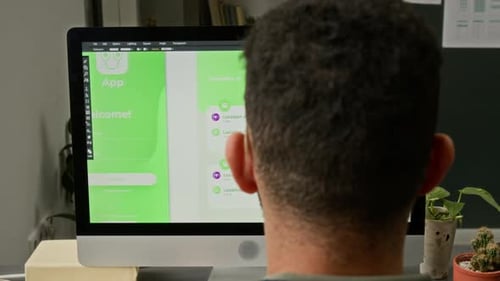 Man Designs App Interface on Computer in Office