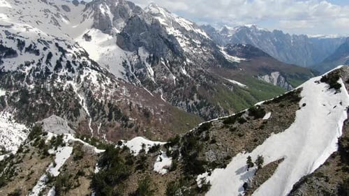 Vista de Zumbido en Albania en los Alpes volando sobre un pico montañoso nevado y rocoso, vista de cerca en Theth