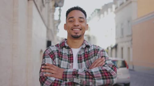 Portrait of a Young African American Man on the Street A Young Guy Stands on the Street and Looks at
