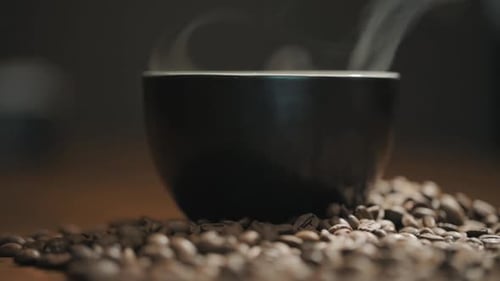 Coffee beans and a steaming cup of coffee