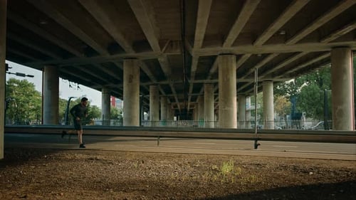 Athletic Young Man in Black Sports Outfit is Jogging in the Street. He is Running in an Urban Envir