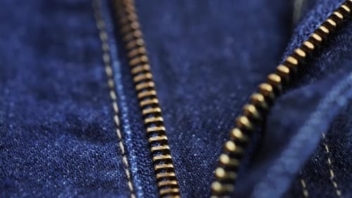 Zipper on jeans close up footage. Close up of blue textile jeans texture. Cotton casual clothes.