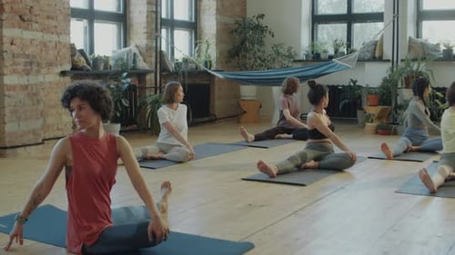 Women Practicing Yoga in Bright Studio