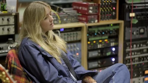 Blonde-haired Female Artist Sitting In Recording Studio And Vibing To The Beat, With Audio