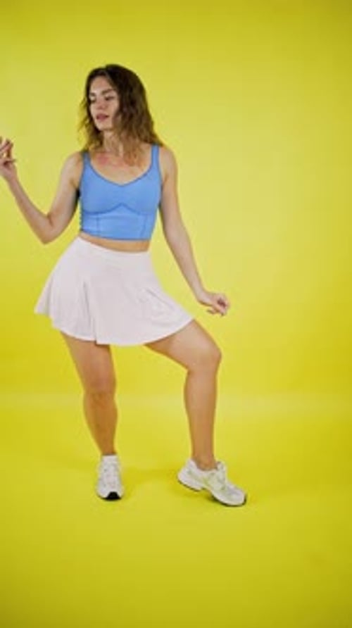Woman Dances Joyfully in Blue Top and White Skirt