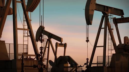 Oil Pumpjacks Operating At Sunset In Industrial Energy Field