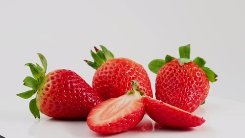 Rotierende reife saftige Erdbeeren auf weißem Hintergrund.