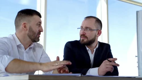 Businessmen Discussing Strategy in Modern Office