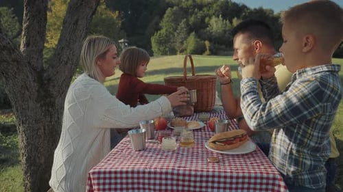 Happy family enjoying picnic the countryside by the forest on a summer day.