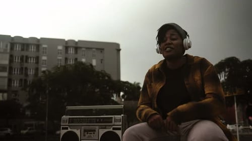 Person Listens to Music Outdoors With Boombox