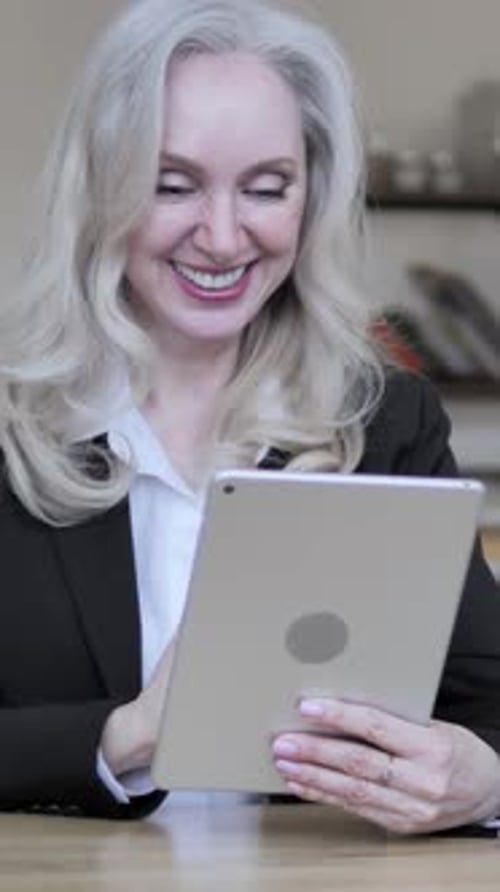 Elegant Woman Video Calling with Tablet in Home Setting