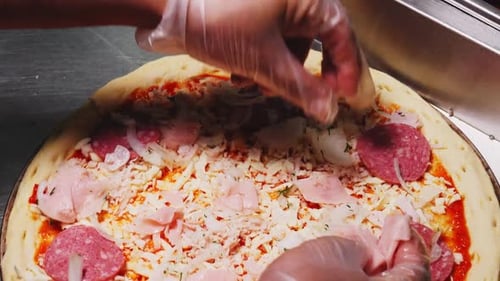 Hands Prepare Fresh Pizza with Meat Toppings