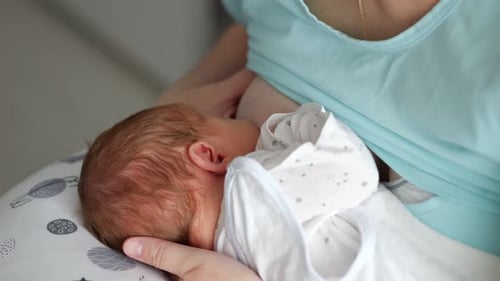 Bebé recién nacido que se alimenta del pecho de la madre