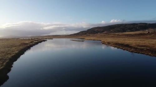 drone flying above river and grass landscape in Iceland