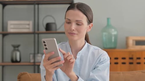 Woman using modern smartphone at home during daytime
