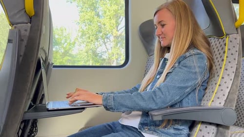 Young Adult Working on Laptop While Riding Train