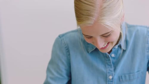 Happy student writing in notebook, university young woman studying at desk table