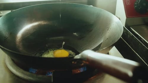 Frying Egg in Wok Pan on Gas Stove for Pad Thai Noodles