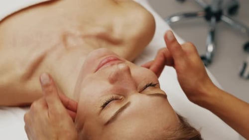 Woman Receiving Rejuvenating Facial Massage at Spa