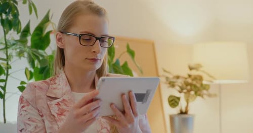 Woman Uses Tablet in Bright Indoor Setting