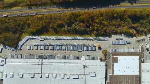 Aerial View of Large Commercial Distribution Center with Many Trucks Unloading and Uploading Retail