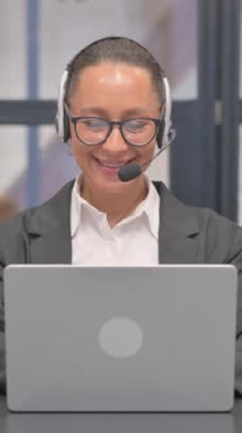 Mixed Race Business Woman with Headset Talking Online with Customer in Call Center, vertical video