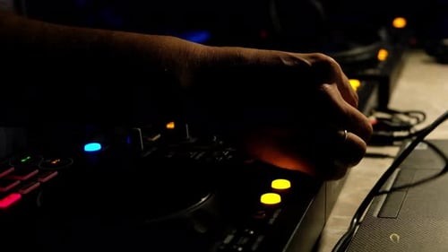 DJ Mixing Sounds on a Deck in the Night