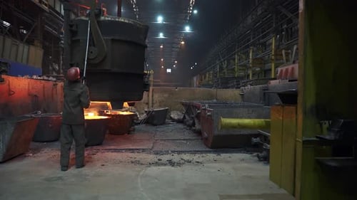 The Process of Metal Pouring in a Modern Industrial Foundry A Worker Engaged in Action Stock Clip