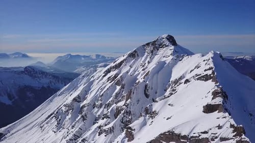 Haut col au-dessus des crêtes enneigées d'une colline alpine