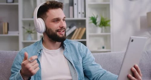 Man with Tablet Enjoys Video Chat in Living Room