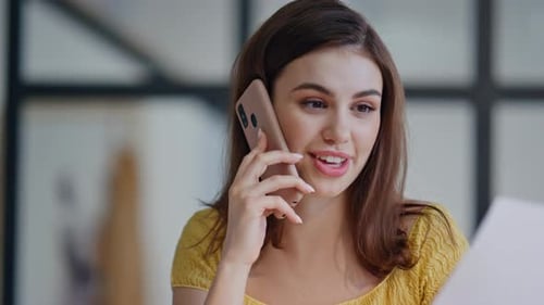 Woman Talking on Phone While Looking at Document