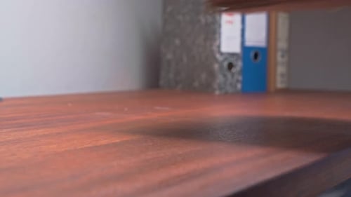 Administrator piles old paper archive documents onto office desktop