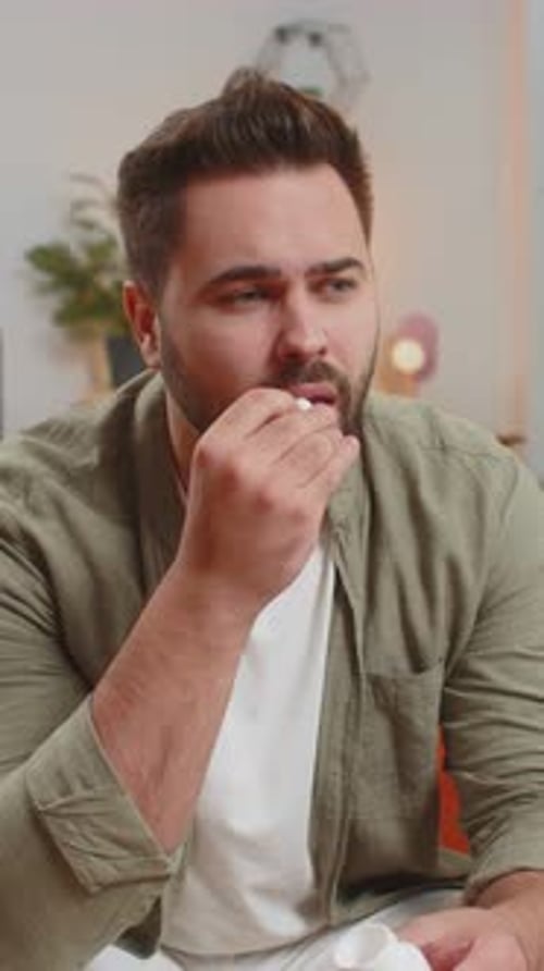 Man Experiencing Headache Taking Medicine Indoors