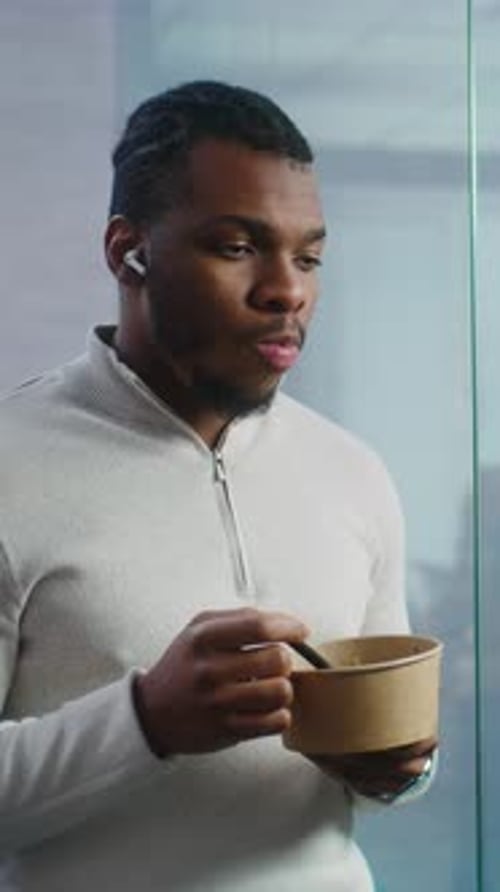 Young Man Eating Lunch in Modern Office