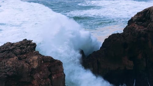 Slow Motioned Waves Crashing Dramatically Against a Rocky Shoreline