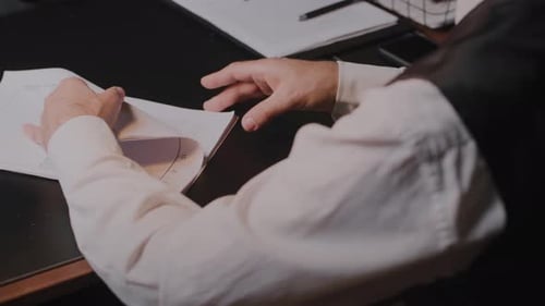 A Businessman is Concentrating on Analyzing Charts and Graphs at His Office Desk